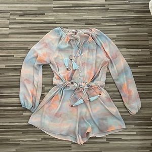 Cotton candy sky like print/color scheme on the romper.